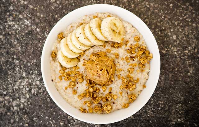 oatmeal with bananas, nuts, and peanut butter on a bowl